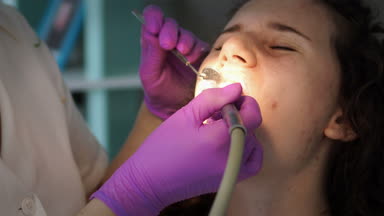 Diş hekimi profesyonel diş diş ofisinde Bayan genç hasta temizlik yapma