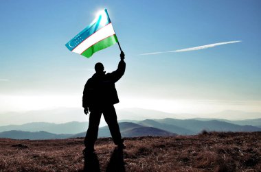 sallama Özbekistan bayrağı dağ tepe üstünde tutan adam silüeti
