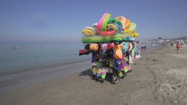 Durres, Arnavutluk - Ağustos, 2017 yaklaşık: satıcı satış mayo ve plaj çocuklar için oyuncaklar