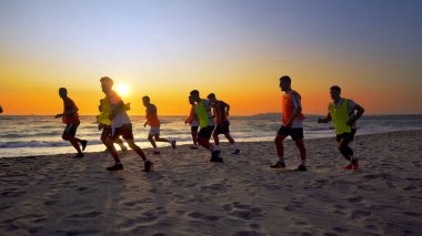 Durres, Arnavutluk - Ağustos, 2017 yaklaşık: futbol spor takımı yapan eğitim deniz günbatımı sırasında koşu