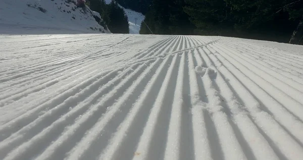Snow lines made from a snow machine on a ski slope, cinematic steadicam shot