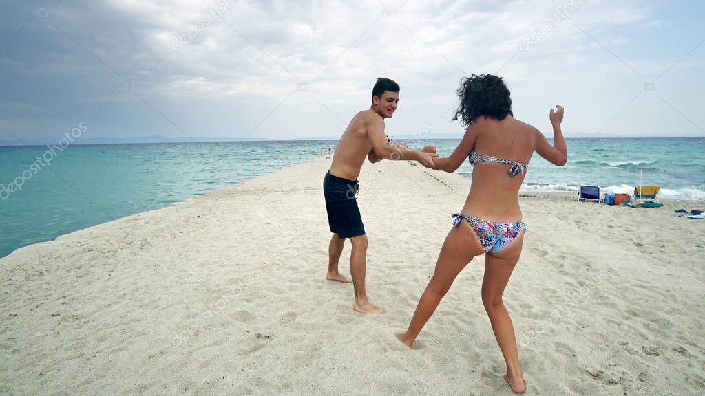 Young couple having fun fighting on beach