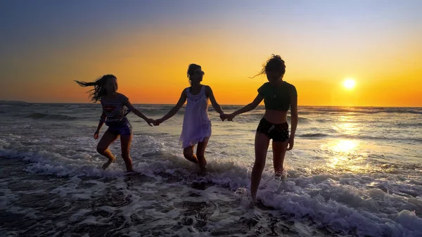 Группа Счастливых Девушек Развлекающихся Морских Волнах Пляже Фоне Заката — стоковое фото