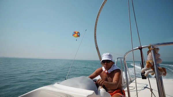 Hand of captain on steering wheel of motor boat on para-sail adrenaline tour in Durres, Albania