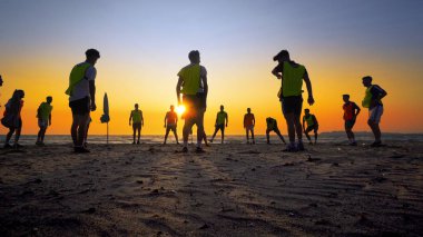 Durres, Albanie - Ağustos, 2017 yaklaşık: Silhouettes futbol takım eğitim günbatımı arka plan üzerinde Beach