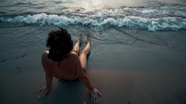 ビキニを着て砂浜で横になっていると夏休みを楽しんでいる女性 — ストック写真