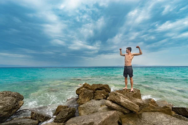Νεαρός Άνδρας Θέτοντας Βράχους Και Απολαμβάνουν Διακοπές Κοντά Στον Ωκεανό — Φωτογραφία Αρχείου