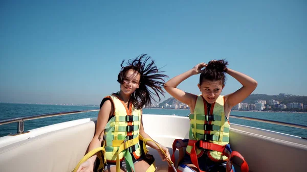 Two girls enjoying trip on boat and dancing