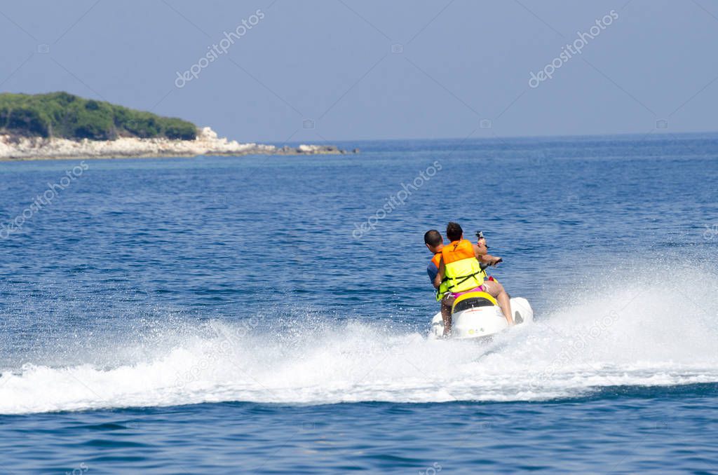 Father and daughter riding on jet ski 