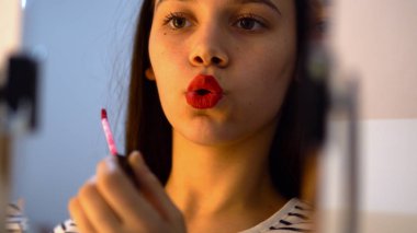 Genç kadın kırmızı ruj dudakları uygulama 