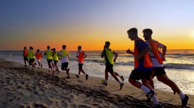 Durres, Arnavutluk - Ağustos, 2017 yaklaşık: futbol spor takımı yapan eğitim deniz günbatımı sırasında koşu