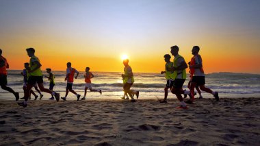Durres, Arnavutluk - Ağustos, 2017 yaklaşık: futbol spor takımı yapan eğitim deniz günbatımı sırasında koşu