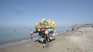 Durres, Arnavutluk - Ağustos, 2017 yaklaşık: satıcı satış mayo ve plaj çocuklar için oyuncaklar