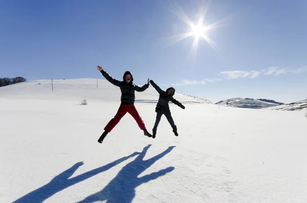 Two Friends Joyfully Jump Sky Snow Drifts Winter — Stock Photo, Image