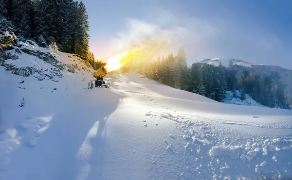 在滑雪场上对日落进行人工雪的炮弹 — 图库照片