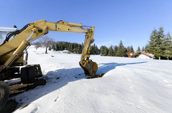 Industriebagger Belädt Erdmaterial Auf Winterlicher Schneebaustelle — Stockfoto