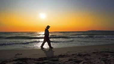 yaz plaj boyunca günbatımı arka plan üzerinde yürüme çift siluetleri