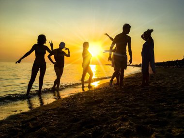 Günbatımı arka plan kumsalda dans insan silüeti