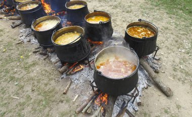 Bir grup kazanlarda ve su ısıtıcısı turist kampında yanıyor. Ordu vintage yemek
