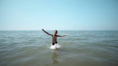 Mutlu çocuk deniz suyundan çıkıyor. Ön sinematik sabit görünüm