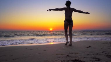 elleriyle geniş açık okyanusta günbatımı arka planda, Özgürlük kavramı yürüyen kadın