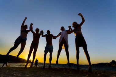 Günbatımı arka plan kumsalda dans insan silüeti