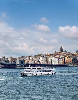İstanbul ve Galata Köprüsü 'ndeki Galata Kulesi' nden Golden Horn 'a uzanan turizm teknesi, arka planda Türkiye
