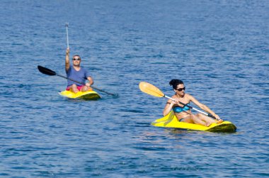 Neşeli çift kanoda kürek çekiyor.