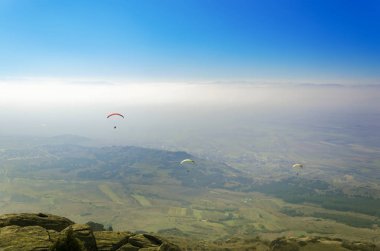 Mavi gökyüzü arka plan üzerinde uçan paraşütler 