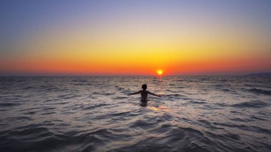 elleriyle geniş açık okyanusta günbatımı arka planda, Özgürlük kavramı yürüyen kadın