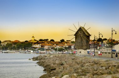 Sunset over old windmill in the ancient town of Nesebar in Bulgaria clipart