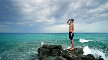 Bulutlu gökyüzü arka plan iskelede duran genç adam