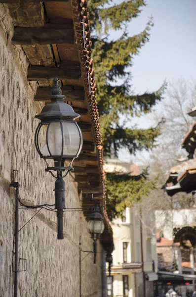 Alley with old stone wall and street light electricity lantern lamp