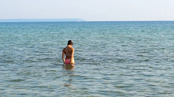 寂寞的年轻女子一个人在海里玩浅水飞溅 — 图库照片