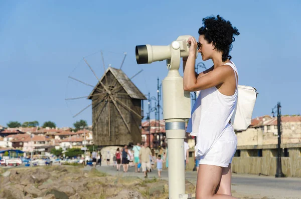 Woman looking in coin observation binoculars in old town of Nesebar in Bulgaria