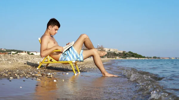 在海滩海岸享受假期的年轻人和读书书 — 图库照片