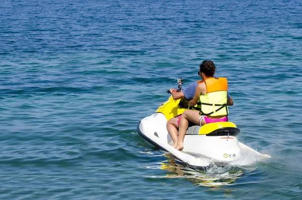 Father and daughter riding on jet ski