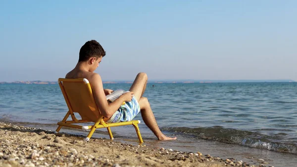 Jonge Man Genieten Van Vakantie Strand Kust Lezing Boek — Stockfoto