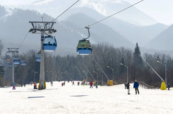 Cableway lift gondola cabins on winter snowy mountains ski resort