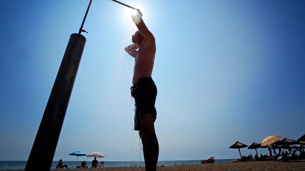 男は太陽に対してビーチにシャワーを浴びて — ストック写真