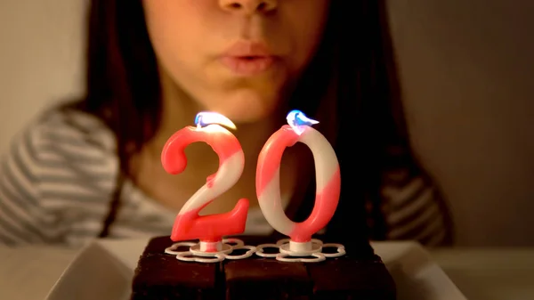 女の子吹いてアウトA 20誕生日キャンドルオンAカップケーキ — ストック写真
