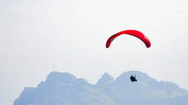 Dağlar arka plan üzerinde uçan yamaçparaşütü siluet