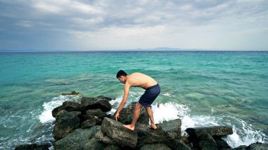 Bulutlu gökyüzü arka plan iskelede duran genç adam