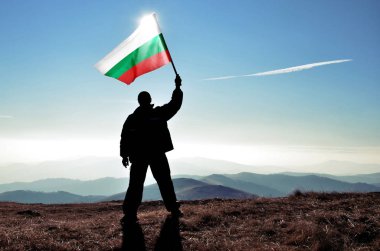 dağ tepe üstünde dalgalanan Bulgaristan bayrak tutan adam silüeti