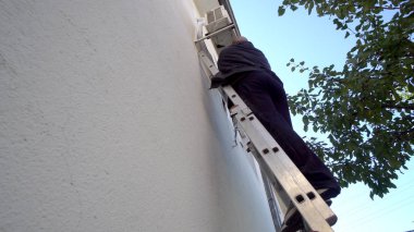 Tamirci açık hava klimasında çalışıyor. Sinematik çekim.