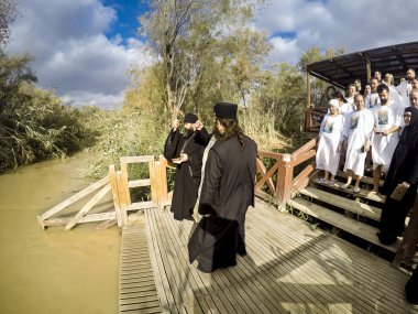 YERICHO, ISRAEL - 20 FEB, 2017: People are waiting to be baptized by water during a baptism ritual at Qasr el Yahud near Yericho on the Jordan river clipart