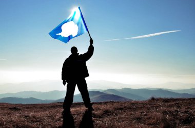 dağ tepe üstünde dalgalanan Antarktika bayrak tutan adam silüeti