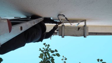 Duvardaki klimayı tamir eden teknisyen.