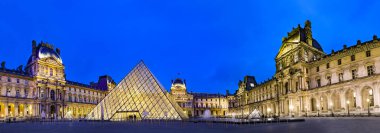 Paris, Fransa - Mayıs, 2017 yaklaşık: Louvre Müzesi alacakaranlıkta panoramik. Paris 30 milyon kişi her yıl çekiyor