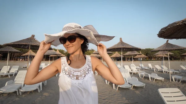 Жінка Білій Сукні Позує Капелюхом Під Час Ходьби Порожньому Пляжі — стокове фото